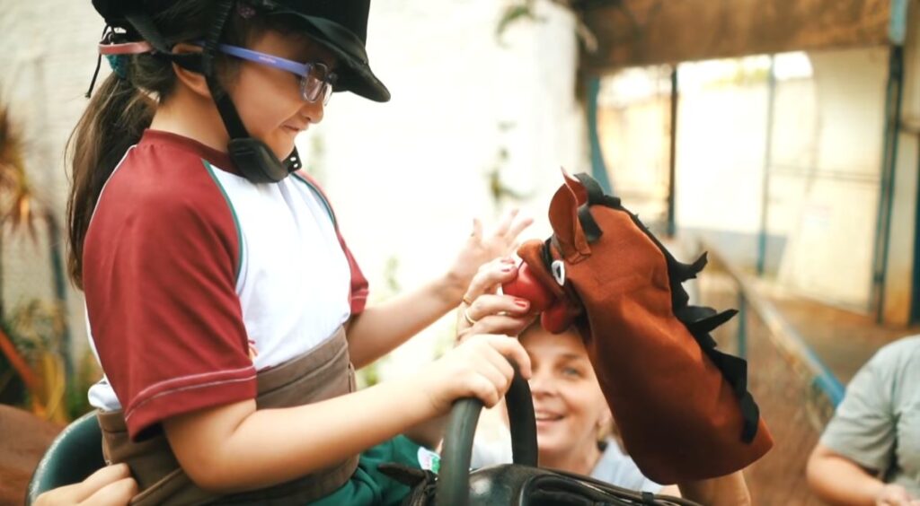 Menina entre 4-8 anos aparentemente montada em um cavalo